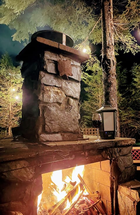 Stone outdoor fireplace adjacent to large deck.neighbourhood