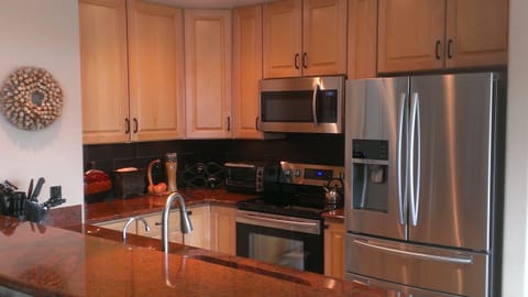 Kitchen features high end slab granite, pull out shelves