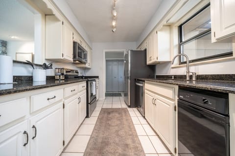 Galley kitchen lookng into hallway I open view into living room