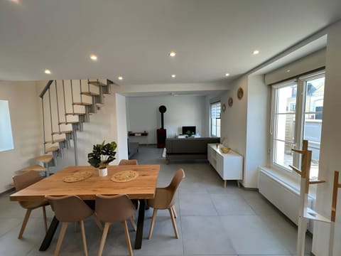 "The dining room is a welcoming space with a wooden table surrounded by matching chairs. It is conveniently located to be open to the kitchen and living room, creating a friendly and harmonious atmosphere throughout the room."