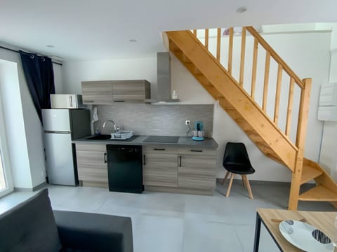 The equipped and fitted kitchen is designed in elegant shades of grey and brown, creating a warm atmosphere. It has a spacious refrigerator to keep food fresh. A modern hob and extractor hood are also installed to facilitate meal preparation.A microwave oven is available to heat dishes quickly. For coffee lovers, a coffee maker is ready to prepare delicious hot drinks. This functional and aesthetic kitchen is the ideal place to cook and share good culinary moments with family or friends.