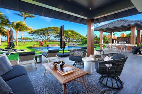 Lounge in comfort on the shaded lanai with ocean views and a serene poolside setting.