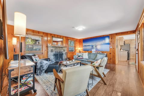 Main Living room with comfortable seating, full fireplace, and large smart TV.