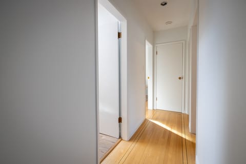 Hallway showcasing beautiful original lined hardwood flooring
