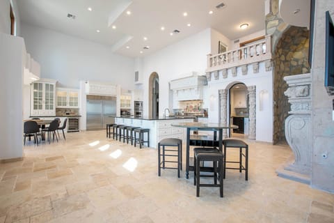 Spacious open-concept area with vaulted ceilings, stone fireplace, and balcony.