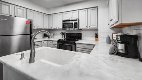 Kitchen: Well-equipped kitchen, stainless steel appliances, white counter and cabinets, range of basic cookware
