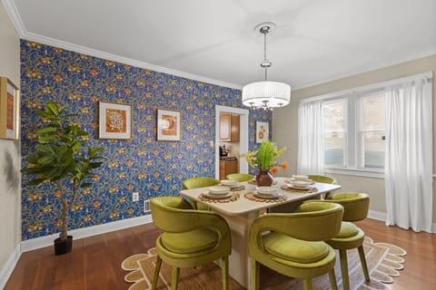 Dining area with indoor plant, and windows with sheer curtains