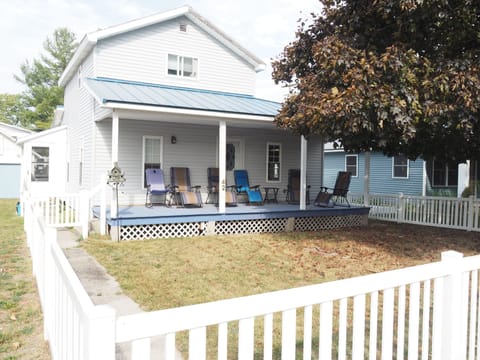 EXTERIOR:  The front of the bungalow, highlighting the front porch and the fully fenced-in yard.