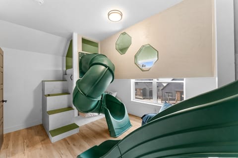 Welcome to The Luxx Fun Room! Our newly constructed kids` bunk room is a dream come true! Featuring two epic slides, your little adventurers can choose their path to fun. Climb the custom staircase to an enclosed balcony leading to cozy beds and two look-