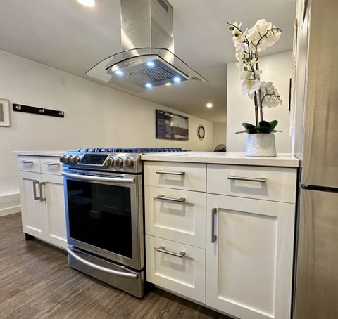 Full kitchen with gas range, refrigerator, dishwasher, microwave, and toaster.
