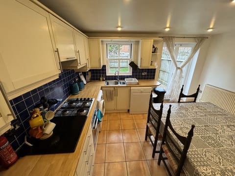 Kitchen with dishwasher, washing machine, Microwave combination oven, gas range.