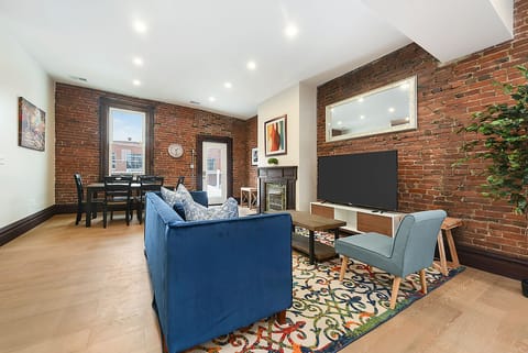 Living area w/ rustic-modern charm, wide TV & plush sofa for relaxation.