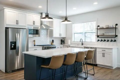 Kitchen island with counter seating and open to the living room and dining room