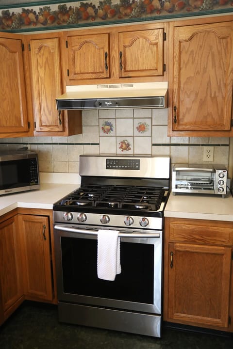 Kitchen showing microwave, stove, toaster oven, and fridge, Laundry room is to the right