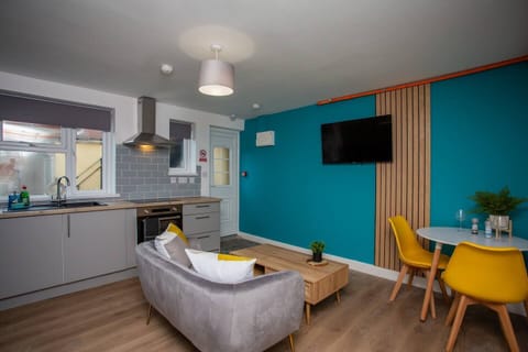 Living room with a state-of-the-art kitchen to assist in culinary endeavors, while a sleek heat extractor ensures a fresh and airy atmosphere as you cook up a storm