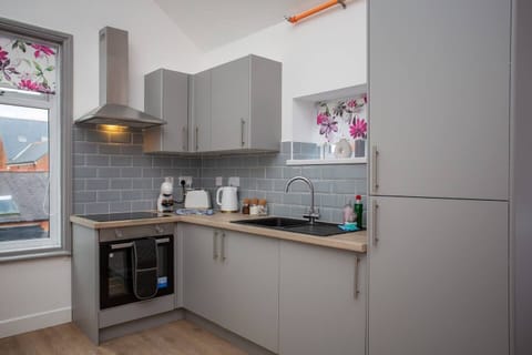 Gleaming countertops and stainless steel appliances create a chef's paradise, while a stylish heat extractor ensures a fresh and airy atmosphere as you cook up a storm.