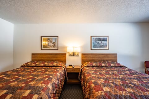 Unwind in this spacious room, tailored for families or groups. Two luxurious Queen-sized beds provide a restful retreat, complete with wardrobe storage for outdoor gear, a coffee maker, and a mini fridge. Comfort and convenience are at your fingertips.