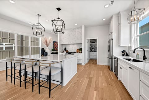 An extra large chef's kitchen with a quartz island and GE Cafe appliances.