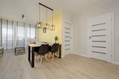Dining area with modern light wood chairs, a round table, and minimalistic design.