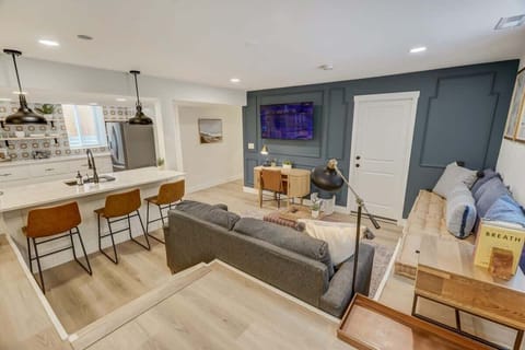 The living space, kitchen, and high-top sitting are all connected by an open floor plan that makes discussion between them simple.
