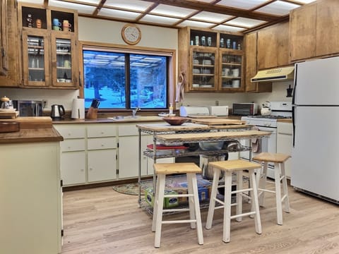 Spacious kitchen, fully stocked, island rack to stash pantry items.