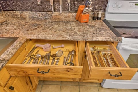 Discover culinary convenience at your fingertips with complete kitchenware and silverware neatly organized in the kitchen drawers.