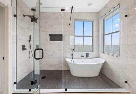 Luxurious primary bathroom with large walk in shower and bath tub.