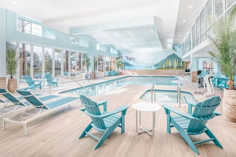 Dive into a sunlit indoor pool with resort-style loungers.