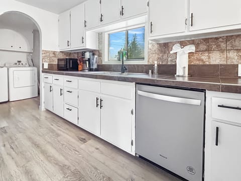 Fully furnished kitchen with oven, microwave, refrigerator, and dishwasher