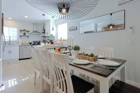 A contemporary dining area seamlessly connected to a modern white kitchen