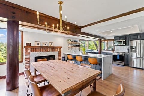 A kitchen island with bar seating complements the dining table,