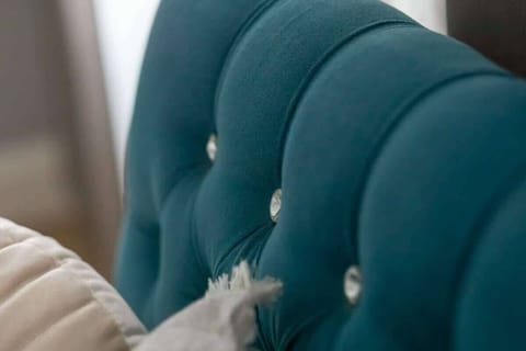 A detailed look at the tufted upholstery on the turquoise headboard, showcasing high-quality craftsmanship and luxurious design.







