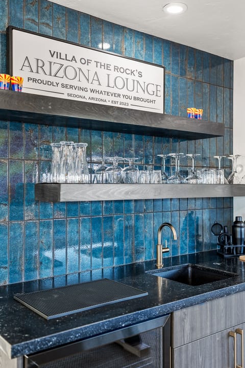 - Sedona kitchen bar with glossy blue tile backsplash - Sleek counter space and modern fixtures for convenience - Perfect area for preparing drinks and entertaining guests