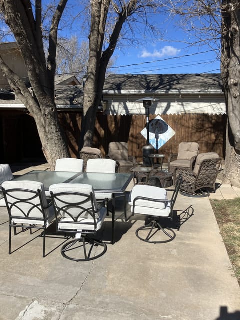 Outdoor dining table and patio chairs around gas fire pit