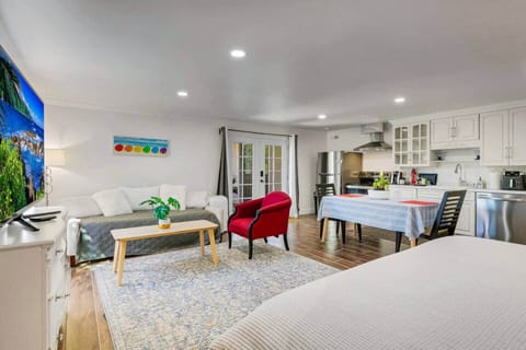 Living room includes a Samsung Smart TV, couch, windows for natural light and ocean breezes. Portable AC unit available. Central Heating. Large dining room table that seats two comfortably. Dining room table can also be used as a workstation.