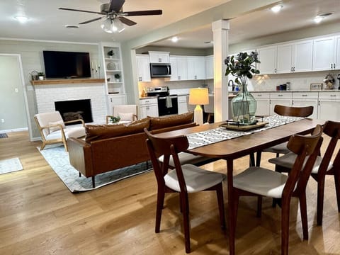 Open floor plan includes fully equipped kitchen, stylish, comfortable living room furniture, and dining table for six (fireplace is nonfunctional)