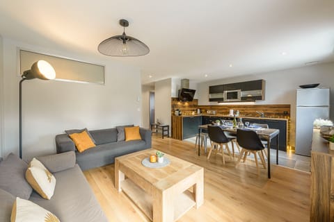 Discover our magnificent, light-filled living room, with its open kitchen and balcony offering a breathtaking view of Imperial and the surrounding mountains.
Enjoy the generous space of this convivial room, ideal for gathering with family or friends. With its modern layout and quality finishes, this living space invites you to relax and enjoy, just a few steps from the beach and the center of Annecy.