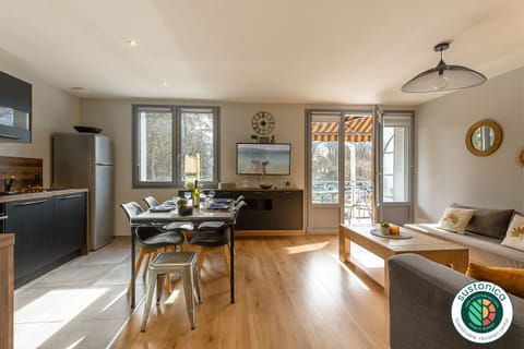 Discover our charming living room located on the 1st floor of the Le Grand Large residence in Annecy, opposite the Impérial. This spacious room features a fully equipped kitchen with oven, microwave, Nespresso coffee machine, dishwasher and full set of crockery. The dining table seats up to 6 for convivial meals. You'll also enjoy a bright, beautiful living room with double sofa and connected TV, ideal for relaxing after a day of exploring. Access to the small balcony lets you enjoy the fresh air and surrounding views.