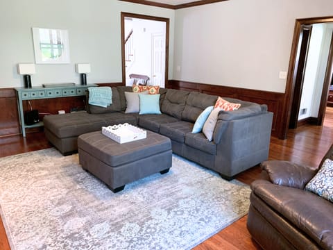 Living room with sectional, recliner, gas fireplace, and large TV