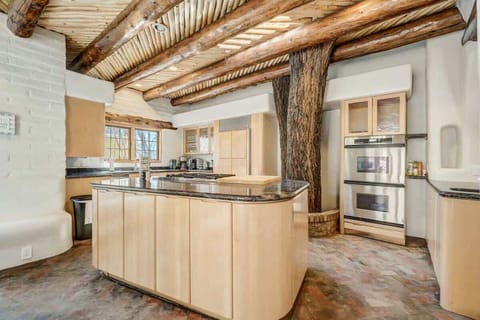 Behold, our kitchen masterpiece! From the expansive center island with a granite top to the fully stocked cabinets, stove, and charming live tree, every detail is designed for culinary delight.