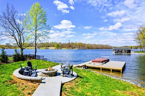 Experience lakeside leisure with a cozy fire pit and boat dock set against a picturesque backdrop of water and sky