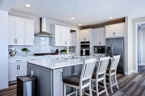 Large fully stocked kitchen with huge island, new stainless steel appliances, and pantry.