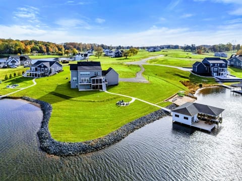 A spacious lakefront home with a large yard, fire pit area, and a private boathouse, offering a perfect retreat for outdoor enjoyment