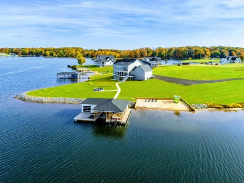 A picturesque lakefront property featuring a private boathouse, sandy beach, and spacious lawn, perfect for a serene vacation