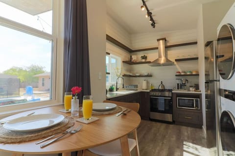 Crisp white shiplap graces the entire kitchen wall, complemented by sleek brown open shelving. Fully furnished with new appliances – fridge, stove, microwave, coffee machine, and a Ninja blender. Indulge in breakfast for two, bask in the sun!