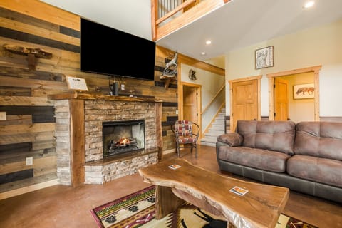 Show Me Mountain Views -- 20-NCD0130 - a SkyRun RMNP Property - Show Me Mountain Views - The living area features a large flatscreen TV, a fireplace, rustic wooden accent furniture, and comfy couches