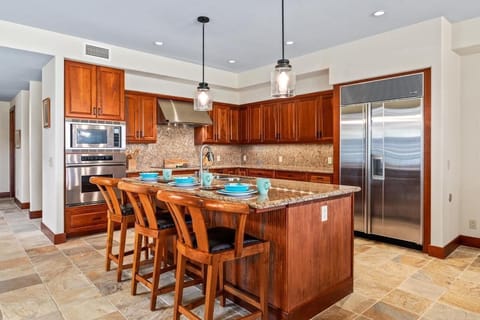 Fully equipped kitchen featuring granite counters and island bar.