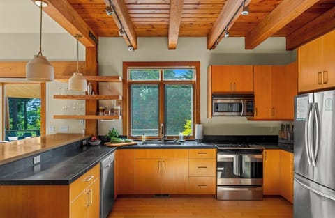 Cook with ease in a bright, fully stocked kitchen framed by forest views.
