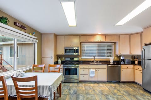 Wide open kitchen with stainless steel appliances and gas range.
