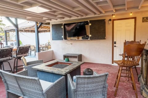 Outside entertainment space with fire pit, 50 inch TV and small bar